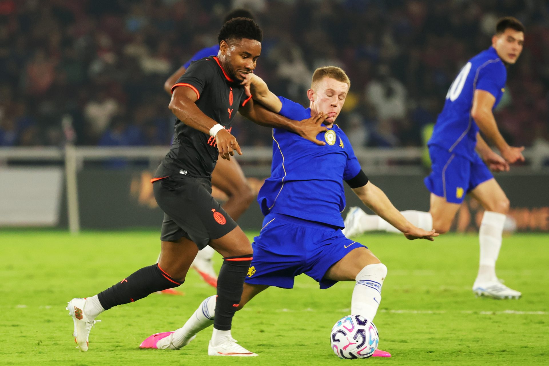 Christopher Nkunku of AC Milan competes for the ball against Reggie Watson of Chelsea
